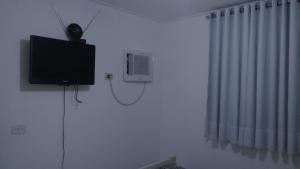 Habitación con TV, radiador y ventana. en Edifício NEO 1, en Maceió