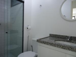 Un baño con inodoro, lavabo y espejo. en Edifício NEO 1, en Maceió 7 fotos más