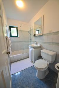 łazienka z toaletą, wanną i umywalką w obiekcie Sunset Deluxe Villa w mieście Vir
