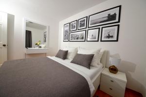 sypialnia z dużym łóżkiem z obrazami na ścianie w obiekcie Sunset Deluxe Villa w mieście Vir