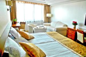 um quarto de hotel com uma cama grande e uma sala de estar em Actor Hotel Budapest em Budapeste