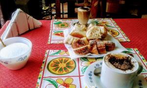 a table with a plate of pastries and a cup of coffee at Residencial Marluc in Río Cuarto