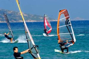 a group of people windsurfing in the ocean at Hotel Porto Puddu - Il Nido dei Gabbiani in Porto Pollo