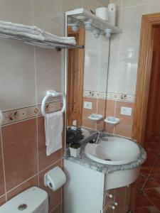 y baño con lavabo, aseo y espejo. en Casa Maye en La Cisnera