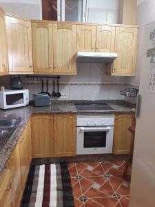 cocina con armarios de madera y horno blanco en Casa Maye, en La Cisnera