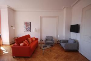 a living room with a red couch and two chairs at Appartements in zentraler Lage in Tübingen