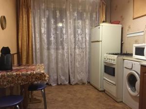 ヤロスラヴリにあるUyut Apartments Chekhovaのキッチン(冷蔵庫、テーブル、電子レンジ付)