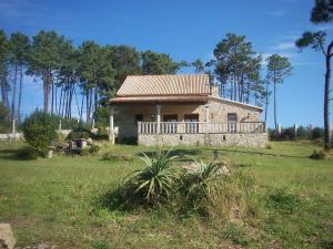 ein kleines Haus auf einem Feld neben einem Wald in der Unterkunft As Covas in Ribeira