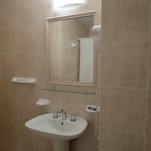a bathroom with a sink and a mirror at Hotel Patagonia Norte in Las Grutas