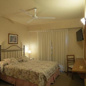 a bedroom with a bed and a ceiling fan at Hotel Patagonia Norte in Las Grutas +42 photos