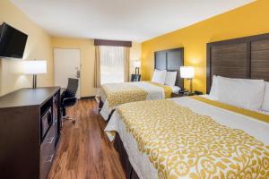 a hotel room with two beds and a flat screen tv at Days Inn by Wyndham Madison in Madison