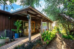 a porch of a house with a wooden deck at Wisteria Cottage in Wyberba