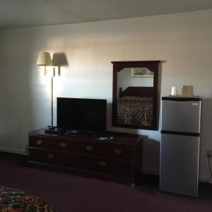 Habitación con TV y tocador con espejo. en Valley Motel Pittsburgh, en Harmarville