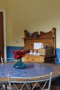 stół jadalny z wazonem kwiatów w obiekcie Kahurangi Cottage Wilderness Retreat w mieście Stanley Brook