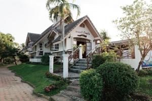 a house with a palm tree in front of it at TaLeKaew Resort SHA in Phitsanulok