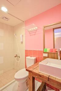 y baño con aseo blanco y lavamanos. en Love Summer Hostel, en Hengchun