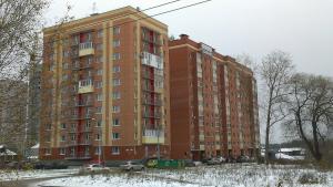 ヤロスラヴリにあるMoskovsky Prospect na Nyutonaの車が目の前に停まった高い赤い建物