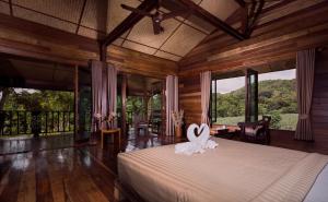 a bedroom with a bed in a room with windows at Bambuh Boutique Homestay in Ban Den
