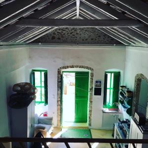 a room with a green door and two windows at Hypate, traditional island cottage in Halki +28 photos