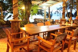 a wooden table and chairs on a patio at Sunset Bungalow Koh Chang Ranong in Koh Chang Ranong