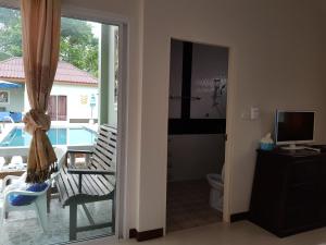 a bathroom with a door open to a balcony with a pool at Khaolak Summer House Resort in Khao Lak