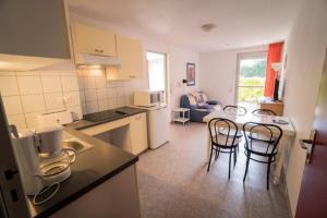 - une cuisine avec trois chaises et une table dans une pièce dans l'établissement Les Pavillons du Rooy, à Salies-de-Béarn