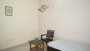 una camera con un letto e una sedia accanto a un tavolo di Golden River a Varanasi
