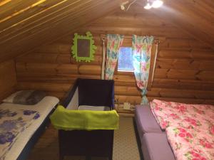 a bedroom with a bed and a couch in a log cabin at Kallioranta Cottage in Ruokolahti