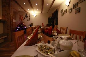 una mesa de comedor con un árbol de Navidad en el fondo en Pawłówka B&B, en Szklarska Poręba