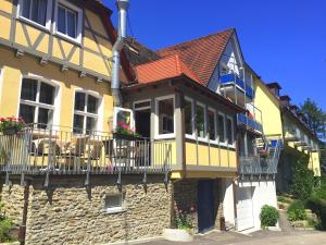 a yellow and white house with a balcony at Hotel Sonneck in Schwäbisch Hall