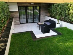 un patio con una silla y una mesa en el césped en Garden Apartment Sun City, en Belgrado
