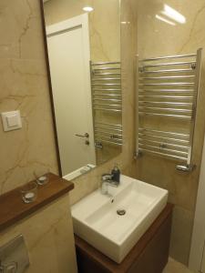 y baño con lavabo blanco y espejo. en Garden Apartment Sun City, en Belgrado