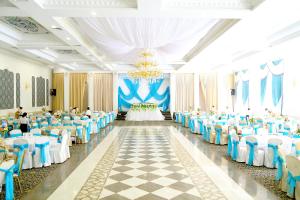 um salão de banquetes com mesas e cadeiras azuis e brancas em Khan Tengri Hotel em Naryn