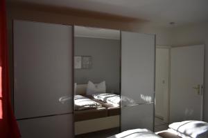 Alt ReddevitzにあるReethaus Boddenblickのベッドルーム1室(ベッド2台、大きな鏡付)