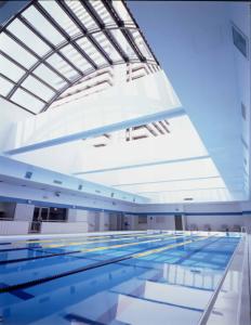 a swimming pool with a large glass ceiling at Hotel Okura Kobe in Kobe