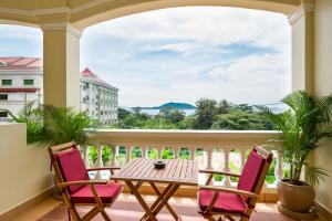 a balcony with a table and chairs and a view of the ocean at Riviera Hotel & Resort Kep in Kep