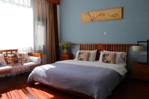 a bedroom with a large bed with a blue wall at Dali Yunxi Boutique Inn in Dali