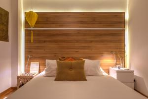 - une chambre avec un grand lit blanc et une tête de lit en bois dans l'établissement epicenter CITY, à Ponta Delgada