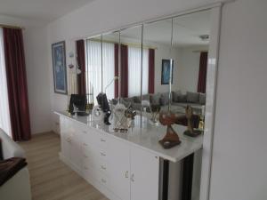 Cette chambre dispose d'une coiffeuse avec un grand miroir. dans l'établissement Ferienwohnungen Haus Panorama, à Neuschönau