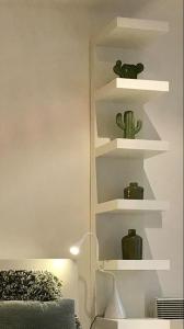 een kamer met witte planken met cactussen erop bij Your suite Ghent in Gent