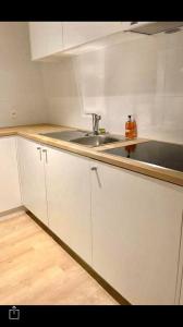 een keuken met witte kasten en een wastafel bij Your suite Ghent in Gent