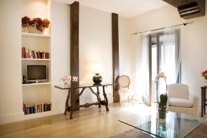 a living room with a table and a tv at Milano Suites in Milan