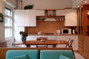 una cucina con armadi bianchi e tavolo in legno di Park apartment a Bellagio