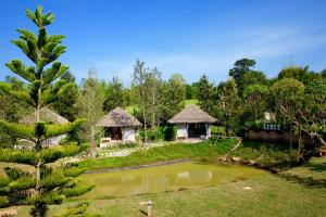 a garden with two huts and a pond at khaokho keree tara in Khao Kho