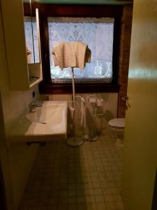 baño con lavabo, ventana y aseo en Barchessa Contarini, en Pontelongo