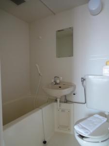 a white bathroom with a sink and a toilet at Soho Asakusa Hotel in Tokyo