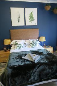 a bedroom with a large bed with a blanket on it at Pillow & Fern in George