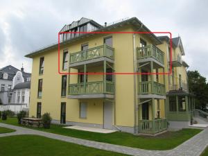 um edifício amarelo com uma linha vermelha em Ferienwohnung Villa Laura em Kühlungsborn