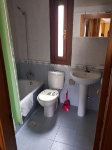 a bathroom with a toilet and a sink at nueva el bosquin in Nueva de Llanes +12 photos