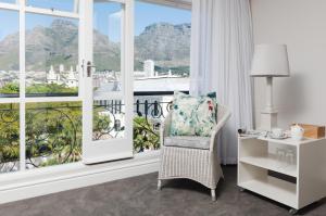 Habitación con silla y ventana grande. en Cape Town Hollow Boutique Hotel, en Ciudad del Cabo